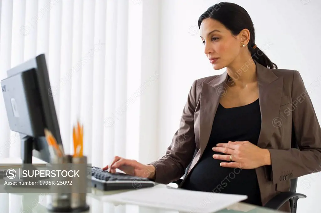Pregnant businesswoman working on computer