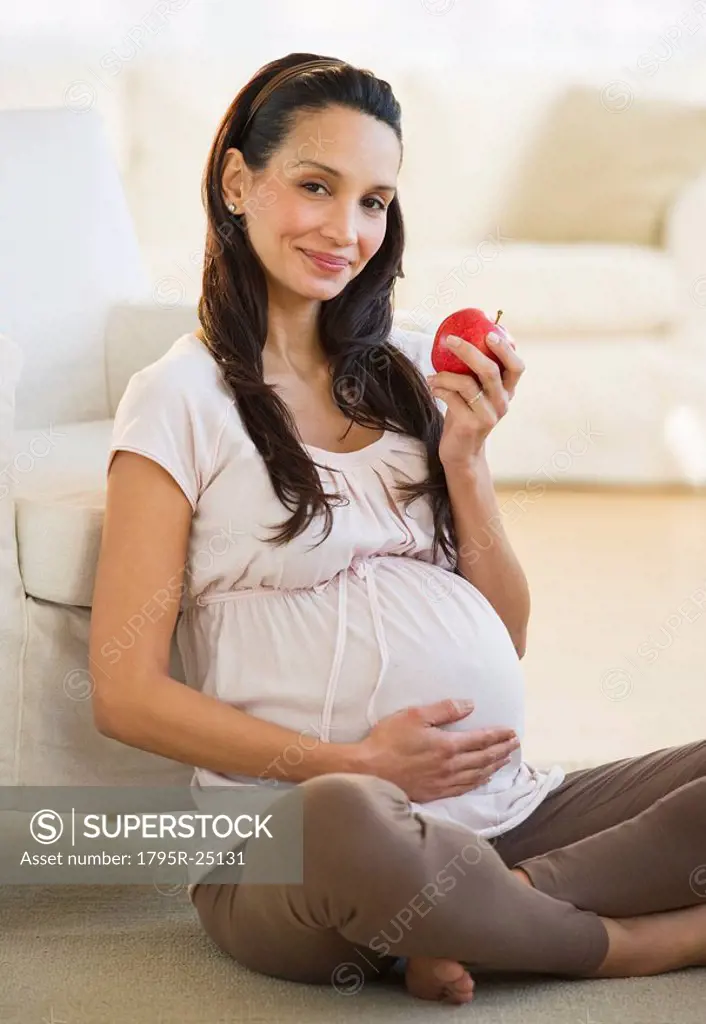 Pregnant woman eating an apple