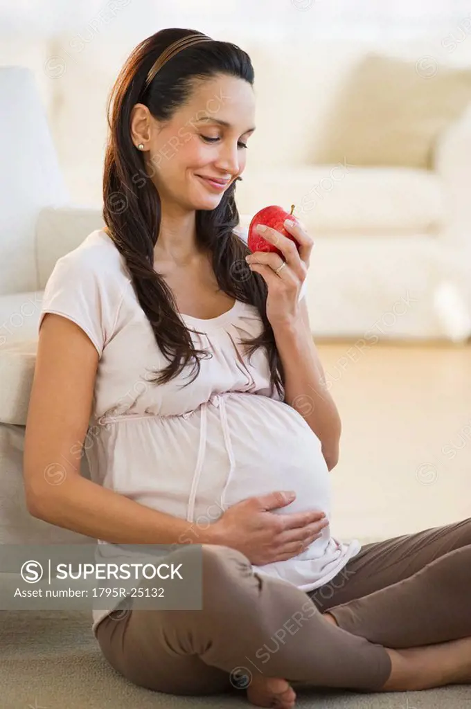Pregnant woman eating an apple
