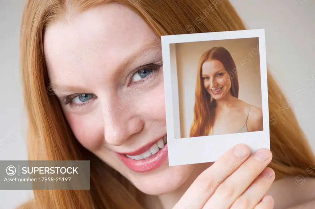 Woman holding a photograph of herself