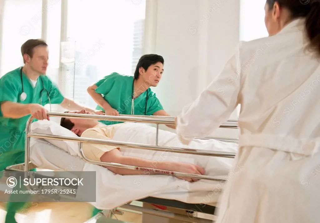 Healthcare workers pushing gurney in emergency room