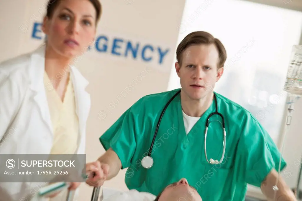 Healthcare workers pushing gurney in emergency room