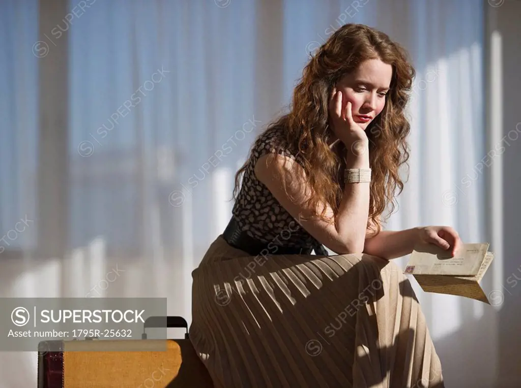 Somber woman sitting on suitcase