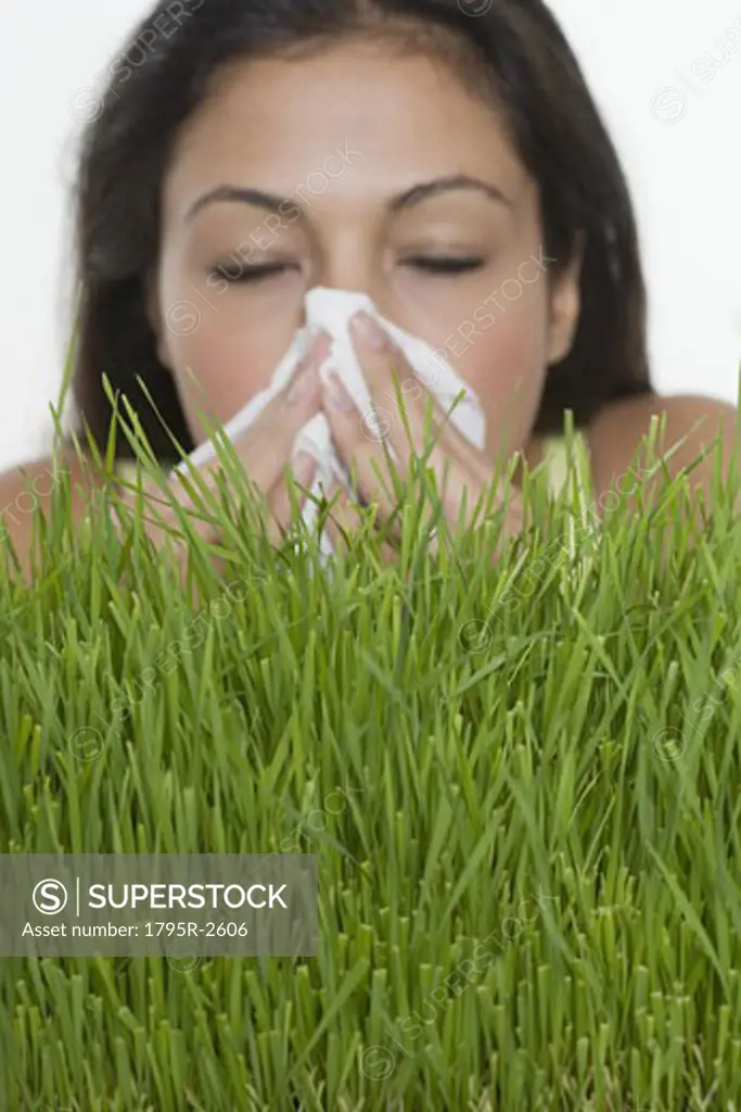 Woman blowing nose with grass