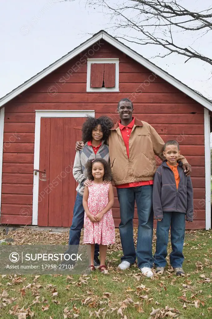 Family standing in front of barn
