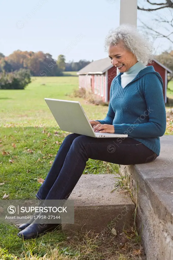 Woman working on laptop on porch