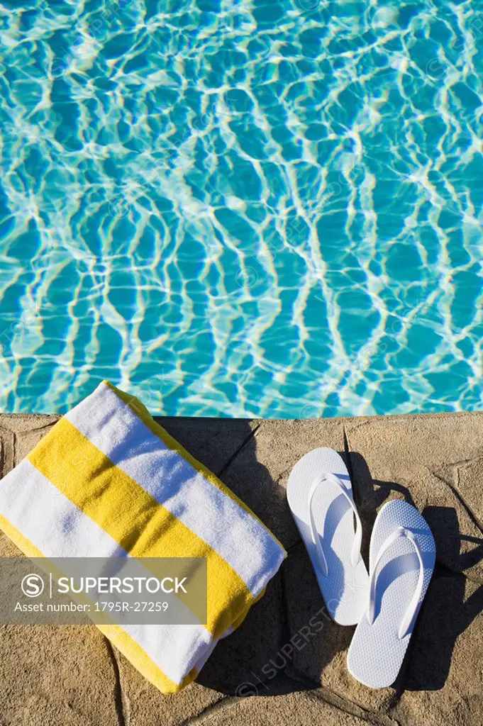 Flip flops and towel by the pool
