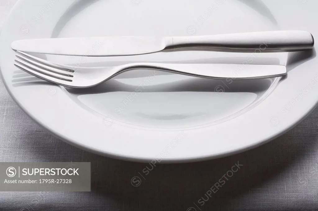 Fork and knife on empty white plate