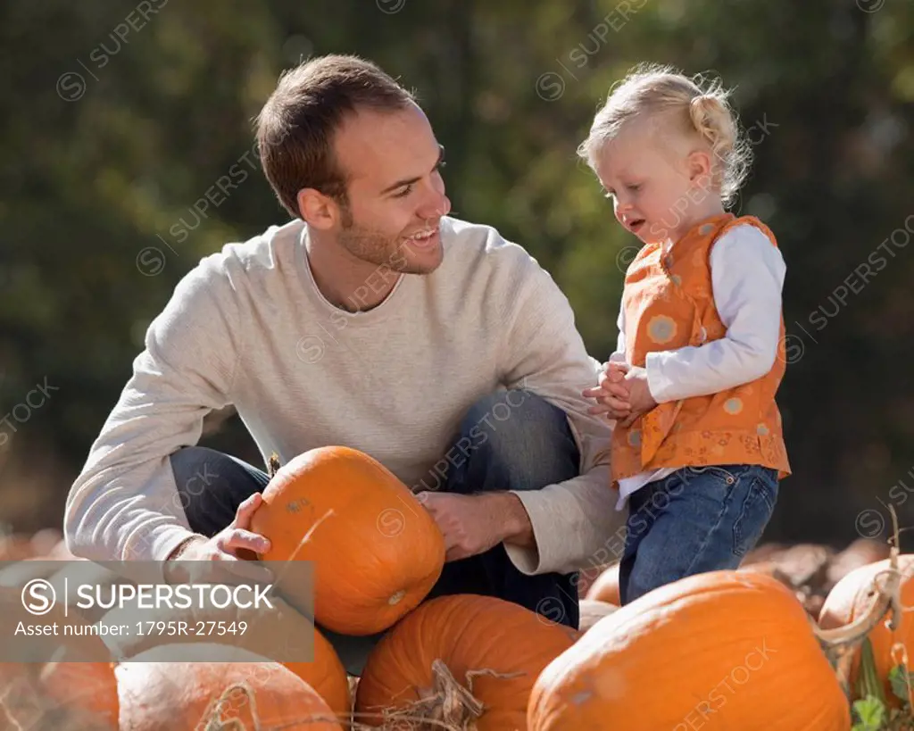 Father and daughter in pumpkin patch