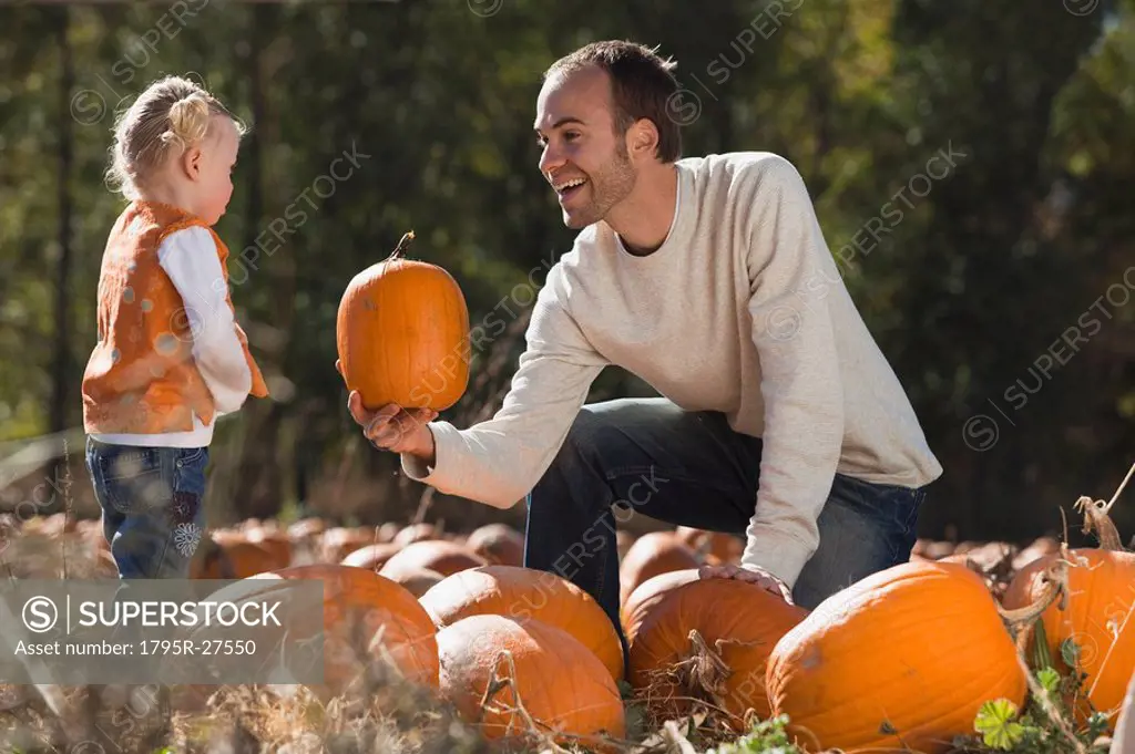 Father and daughter in pumpkin patch
