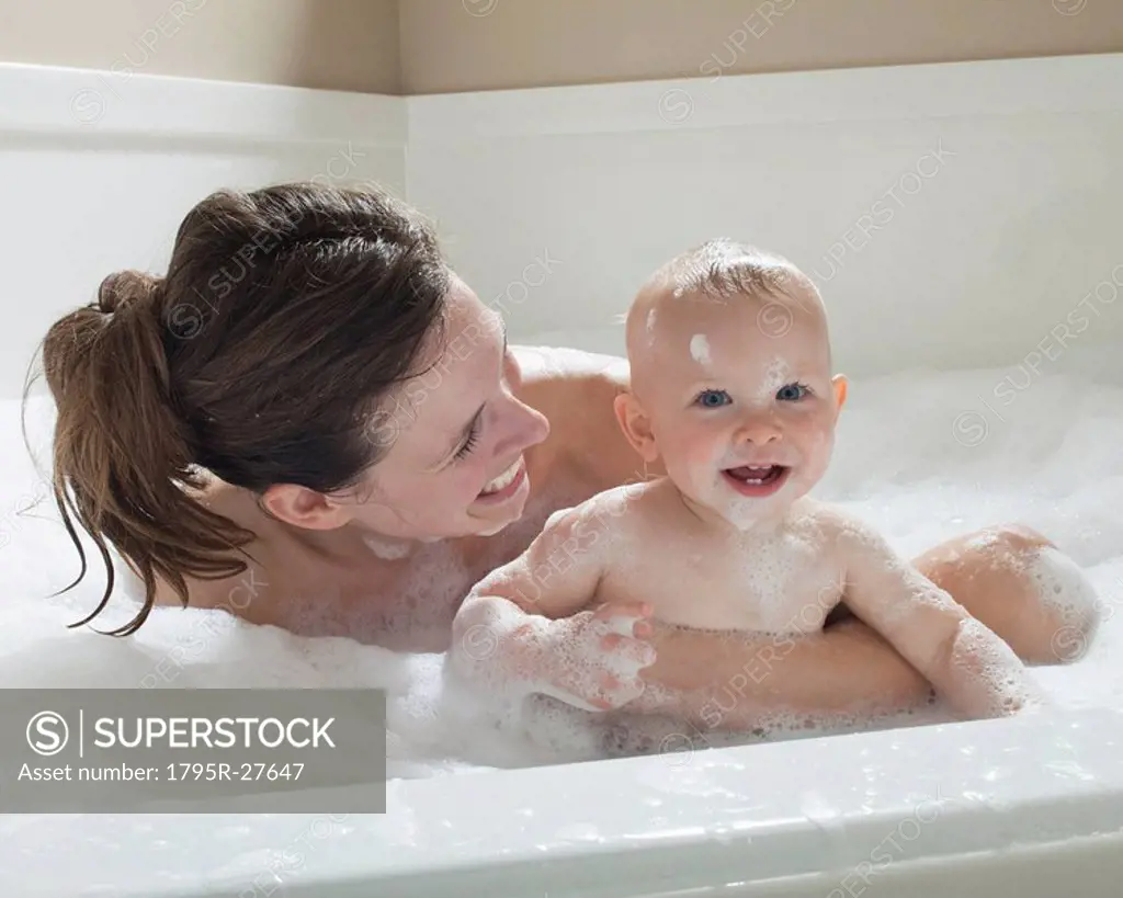 Mother and baby having bubble bath