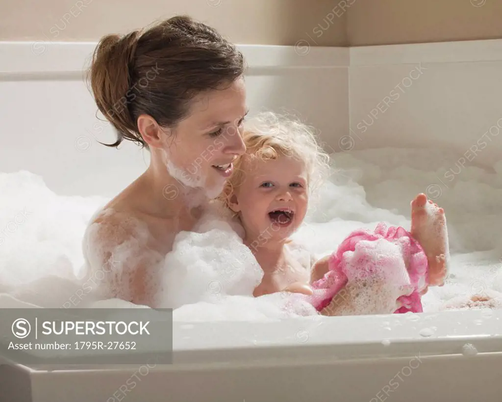 Mother and child having bubble bath