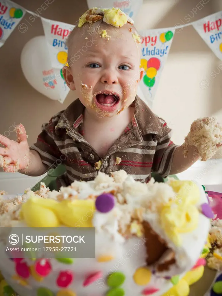 Baby covered in birthday cake