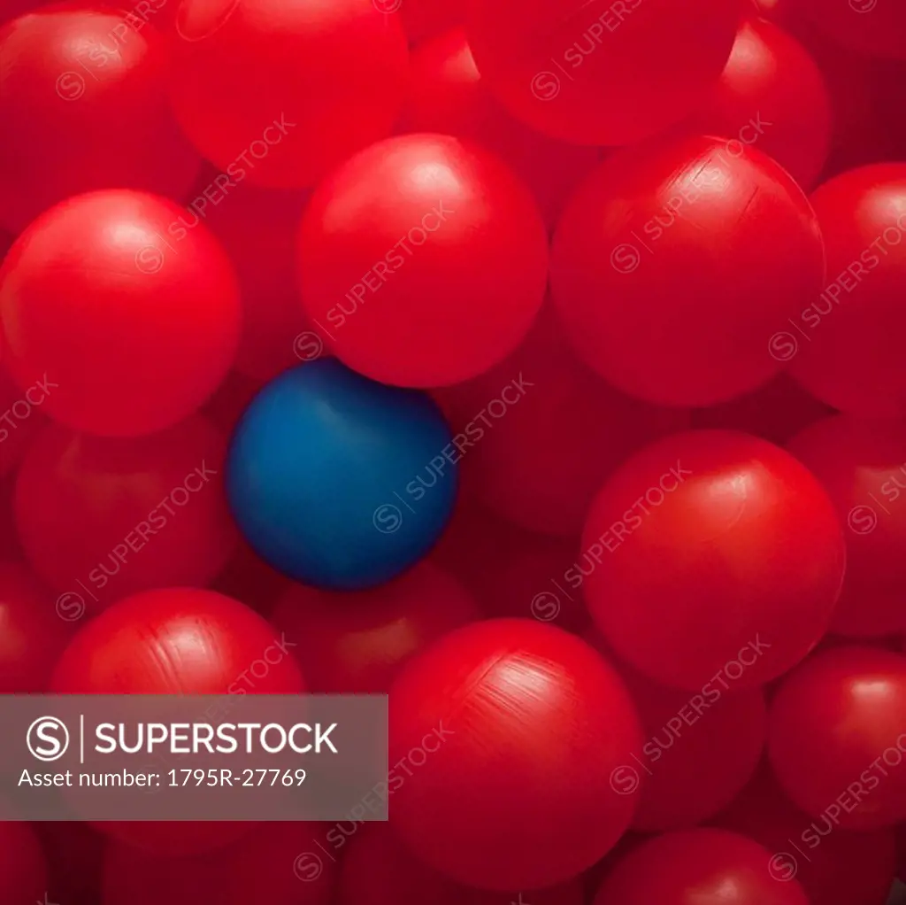 One blue ball amongst many red balls