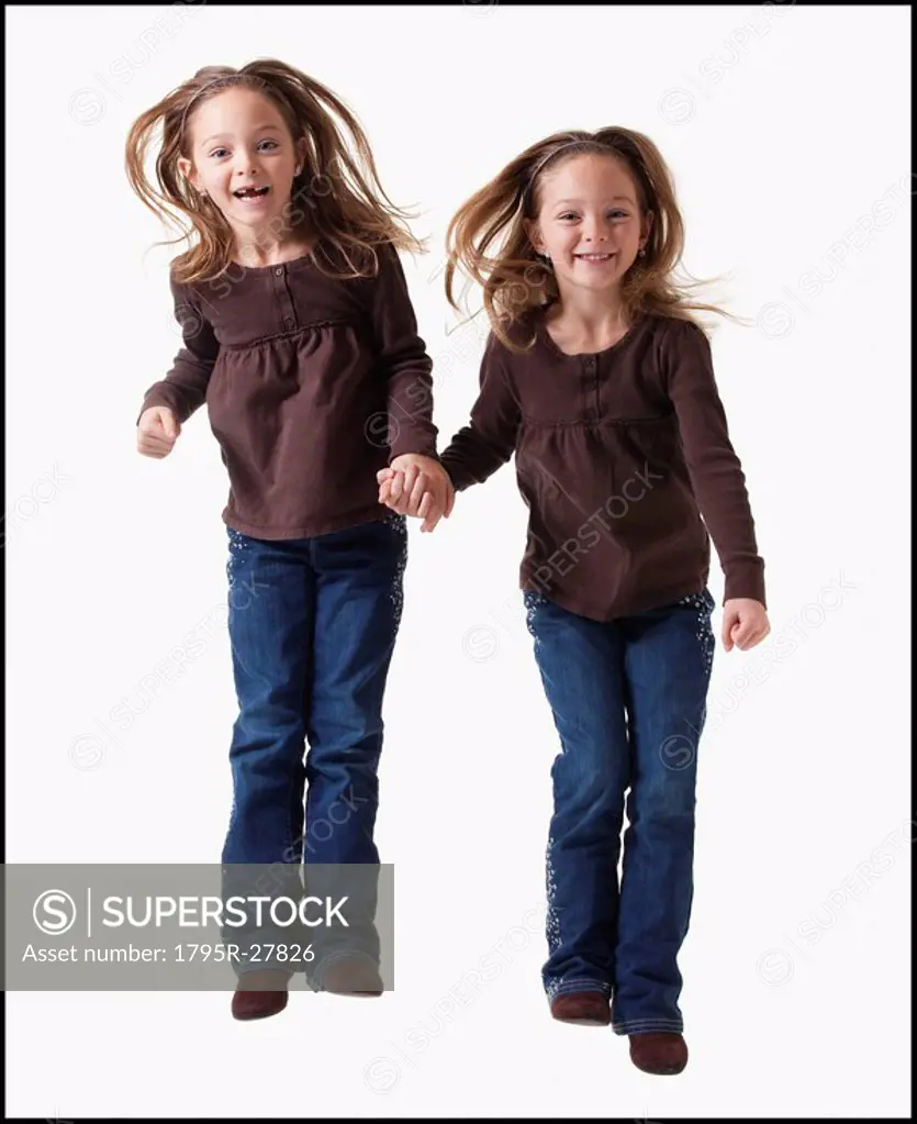 Identical twins jumping