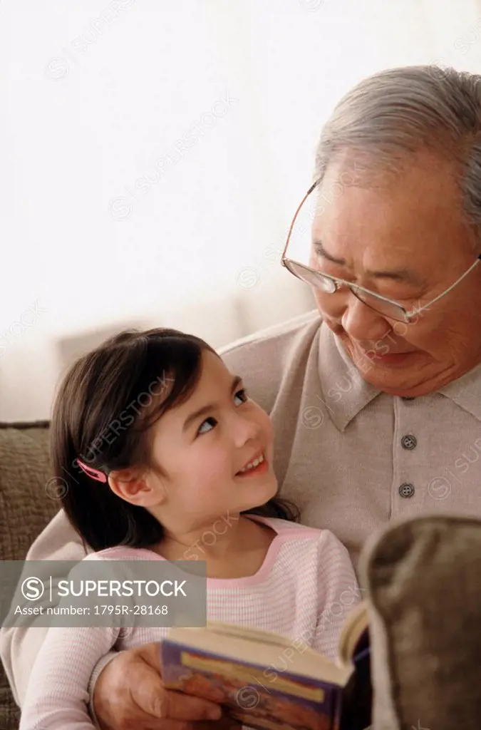Grandfather reading to granddaughter