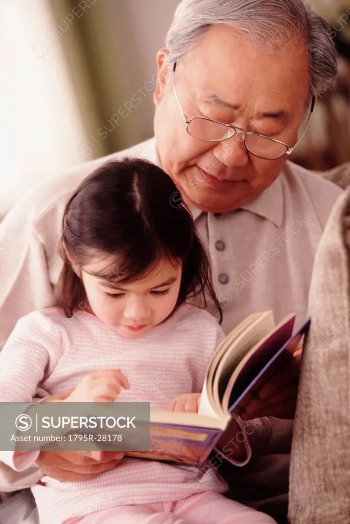 Grandfather reading to granddaughter