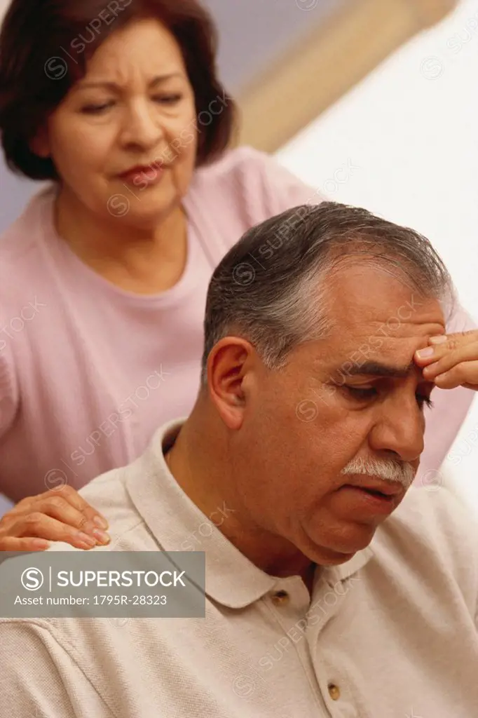 Woman comforting a man with a headache