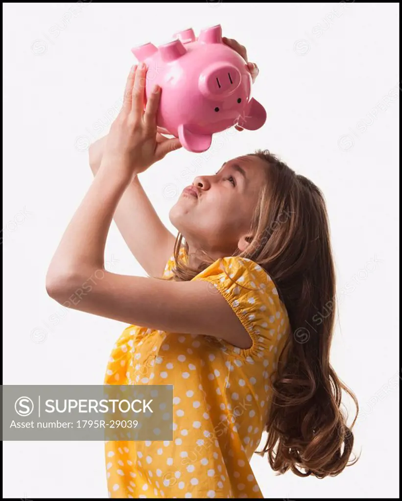 Teenage girl trying to get money out of piggy bank