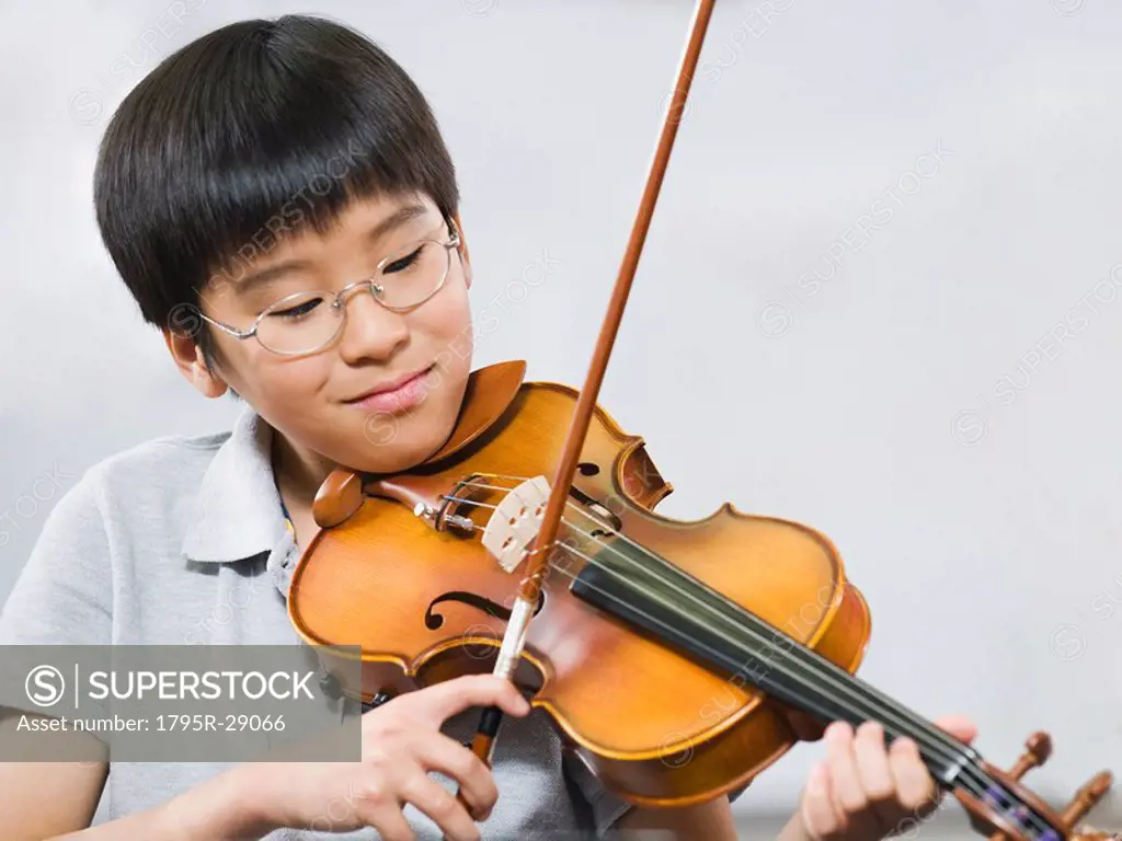 Elementary school student playing violin in music class