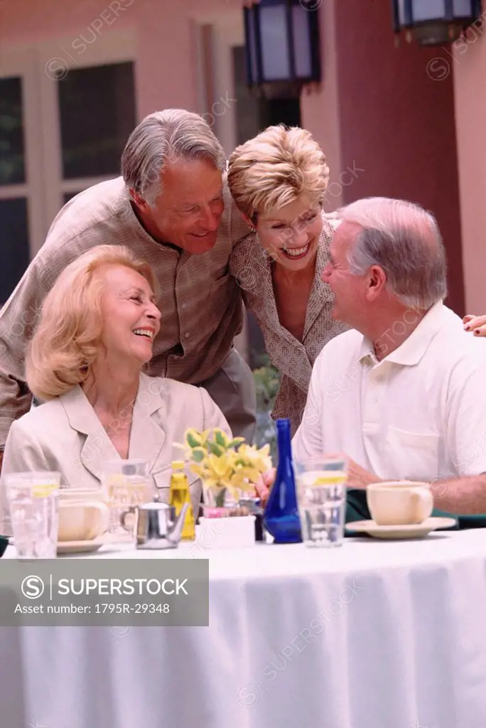 Two senior couples socializing on restaurant patio