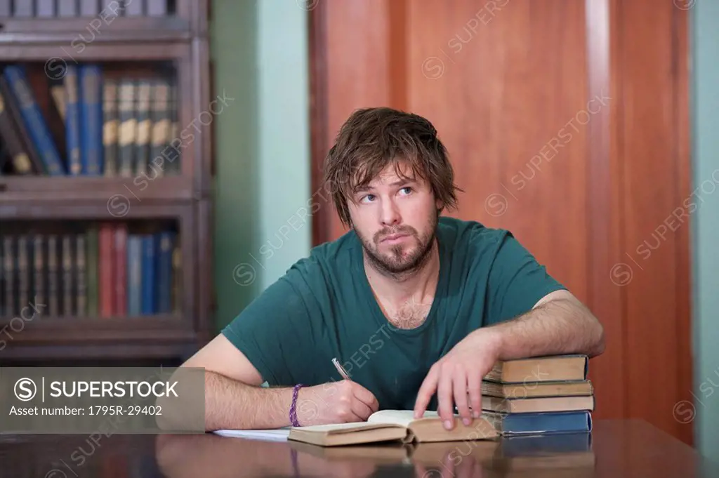 Man in library taking notes