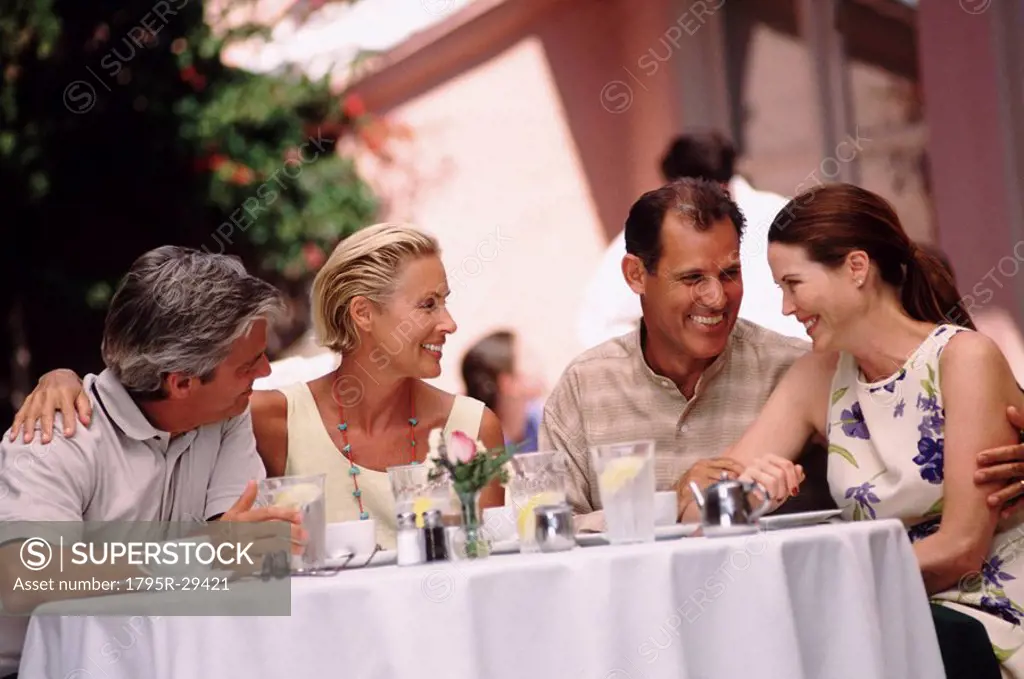 Two couples having dinner on the patio of a restaurant