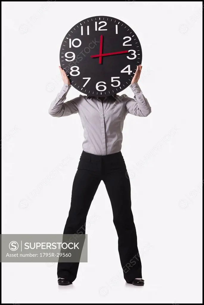 Businesswoman holding clock in front of her face