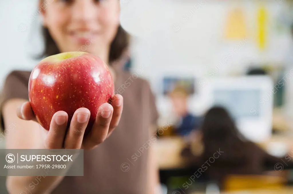 Elementary student holding an apple in her hand