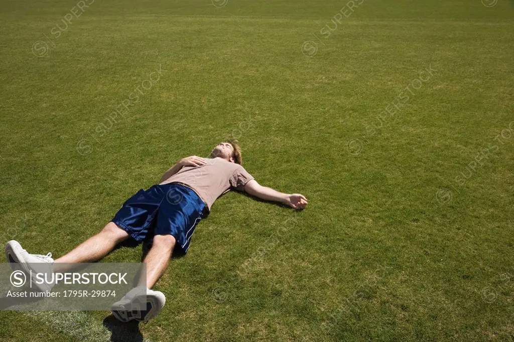 Defeated athlete lying on grass