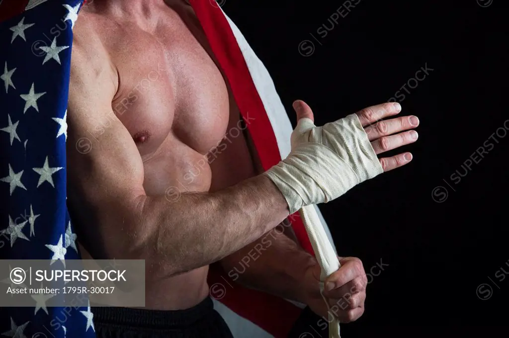 Muscular man wearing American flag as a cape