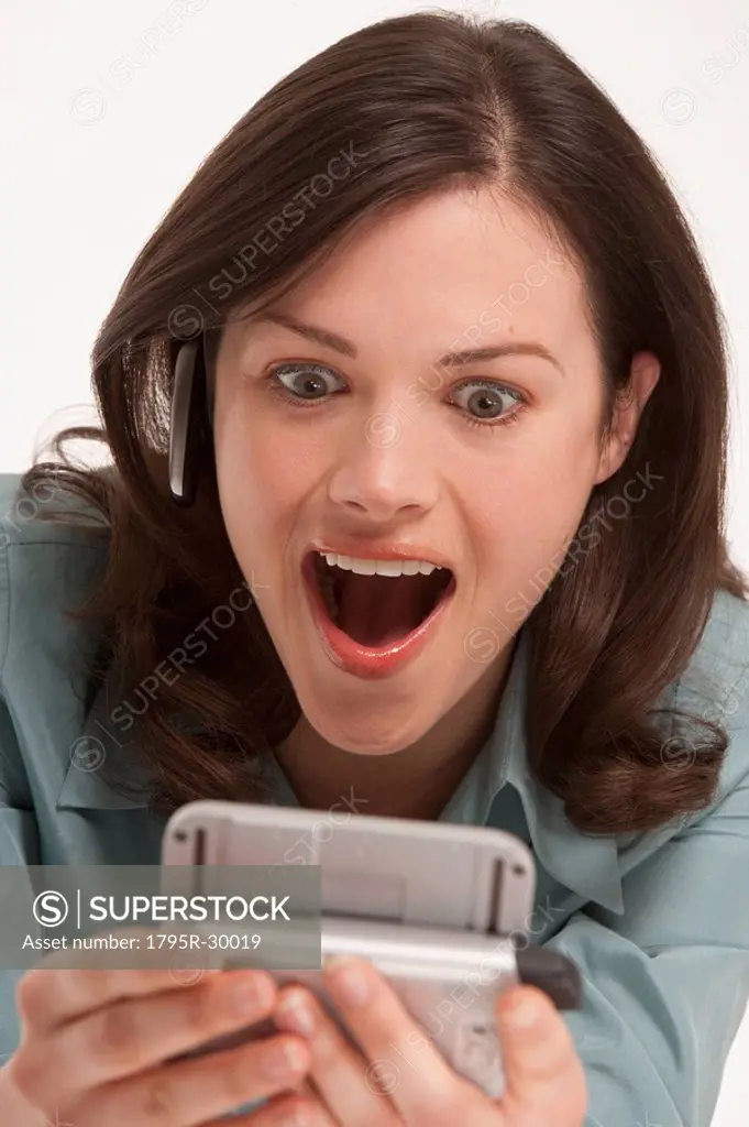 Surprised woman looking at hand held device