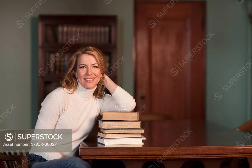Woman leaning on stack of books