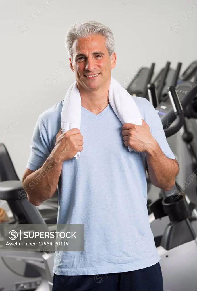 Man at the gym standing with towel around his neck