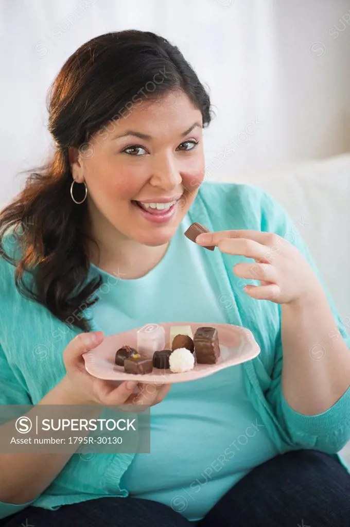 Overweight woman eating chocolates
