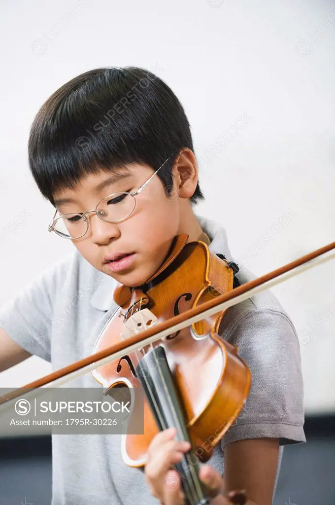 Elementary school student playing violin in music class