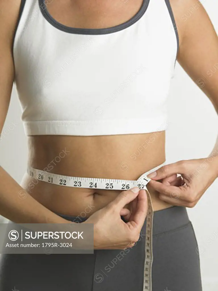 Closeup of woman measuring her waist