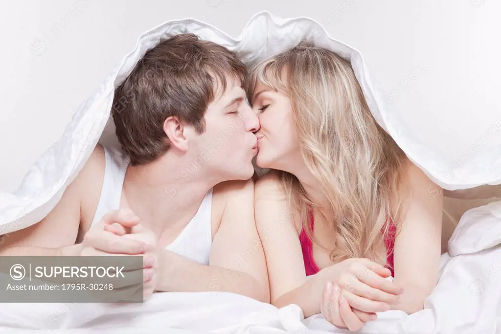 Couple kissing under the covers