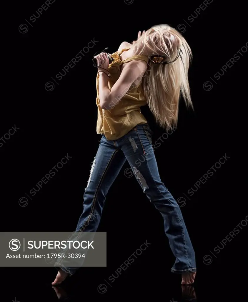Blond woman dancing while listening to music on Mp3 player