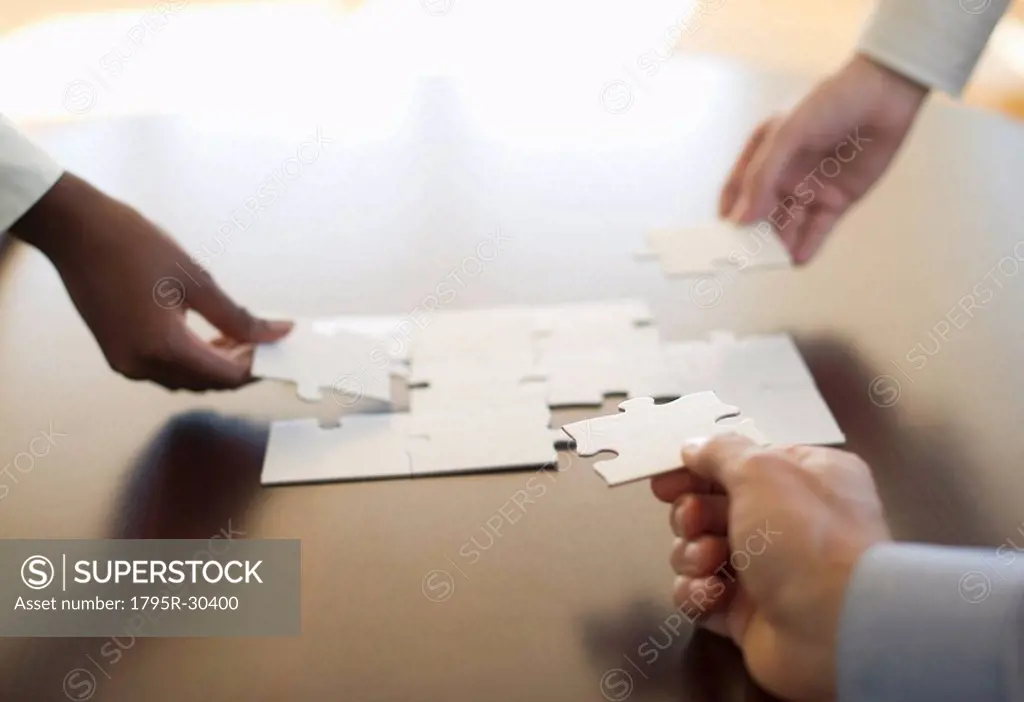 Hands putting puzzle together