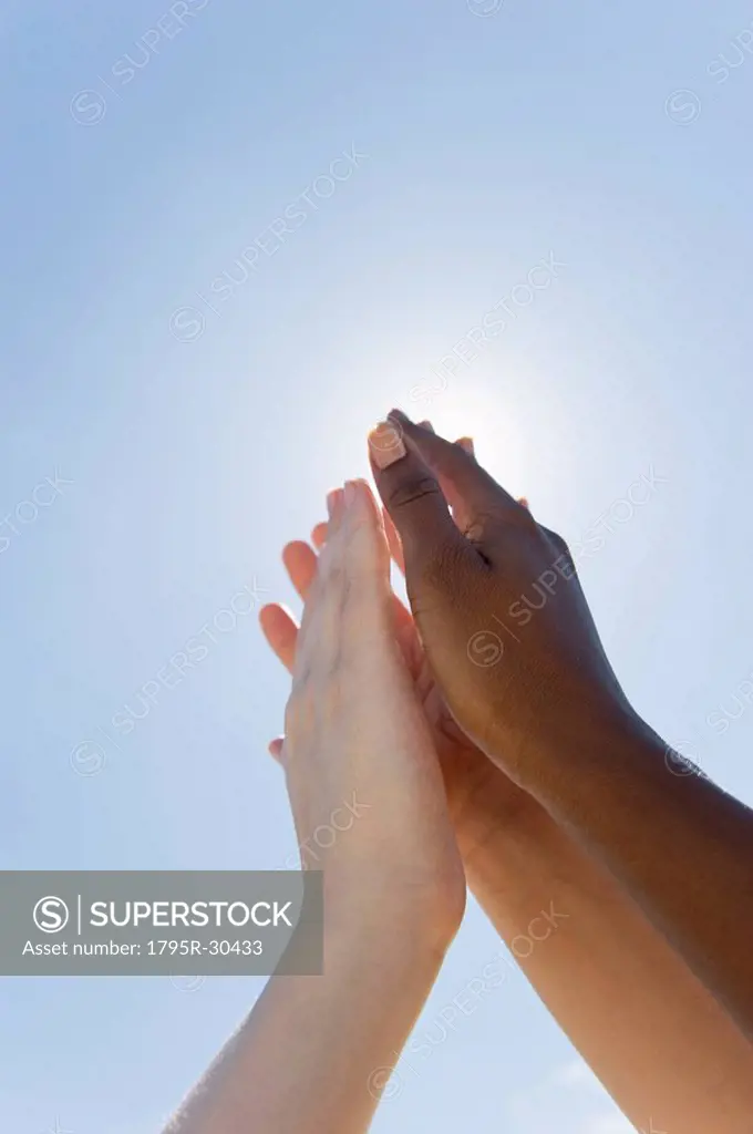 Hands held up in front of sunshine
