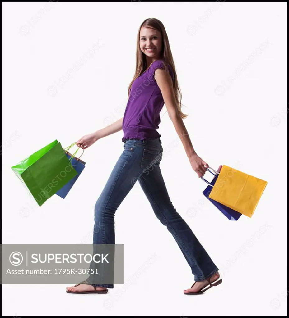 Teenage girl walking with several shopping bags