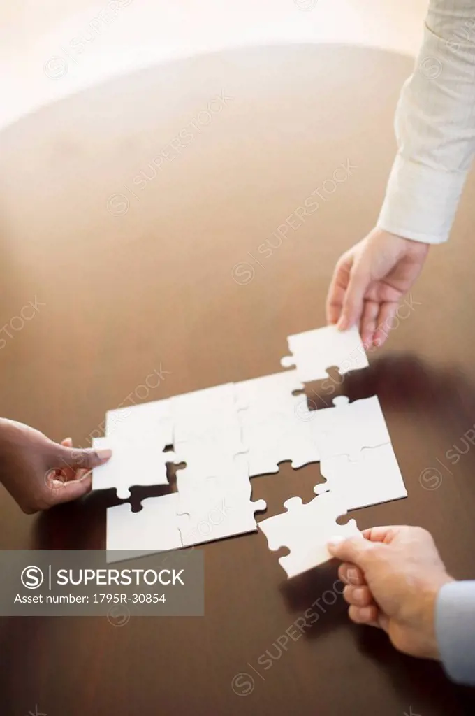 Hands putting puzzle together