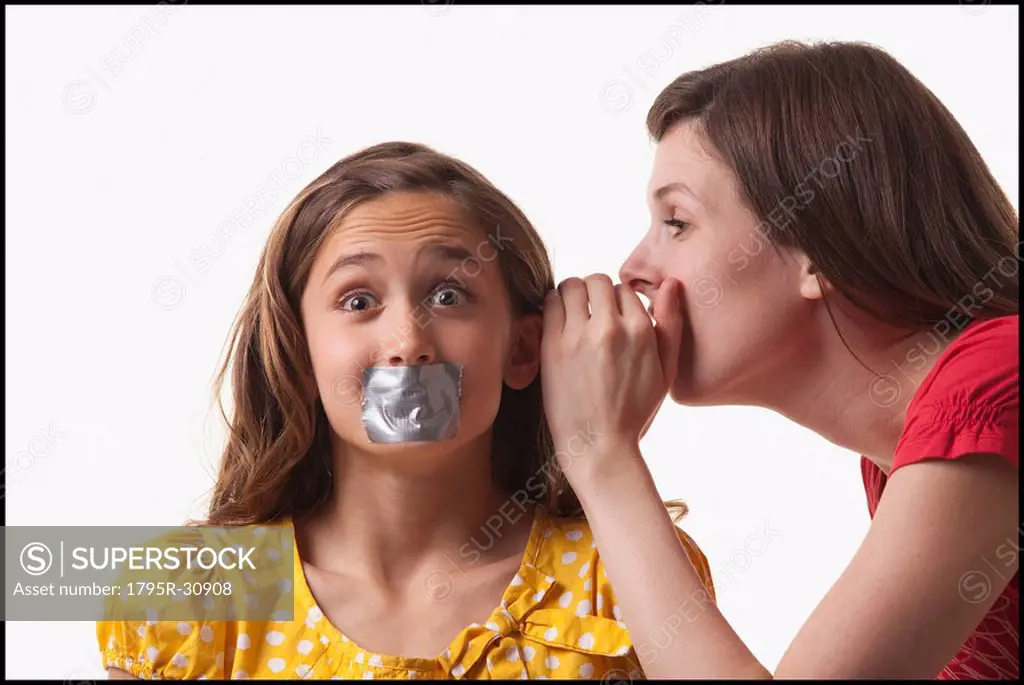 Woman whispering to a frightened girl