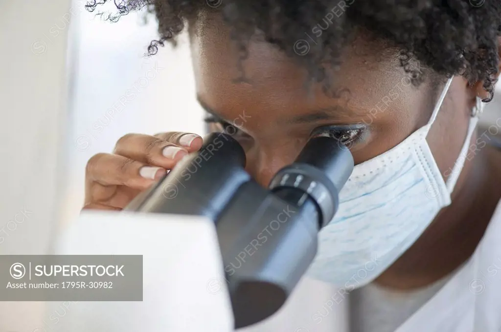 Researcher looking at specimen through microscope