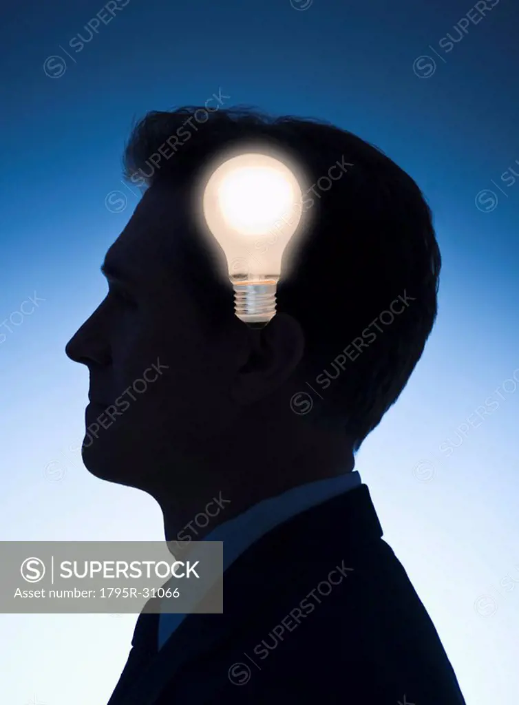 Light bulb in front of profile of a businessman