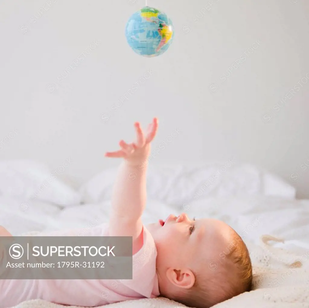Baby reaching for globe