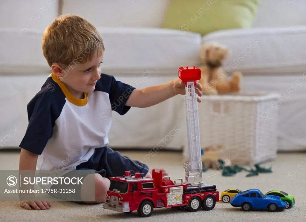 Young boy playing with toy fire truck