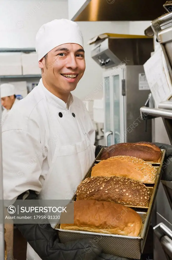 Chef holding tray of freshly baked bread