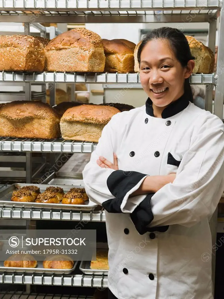 Chef standing beside trays of freshly baked goods